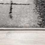 Close-up of textured rug on wooden floor.