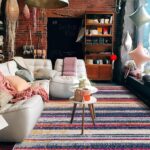 Cozy living room with colorful striped rug.