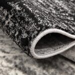 Close-up of a folded, textured black and white rug.