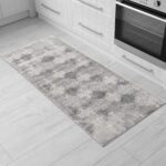 Gray patterned kitchen rug on wood floor.