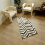 Modern room with zigzag pattern rug, two chairs.