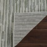 Corner of rug folded on wooden floor.