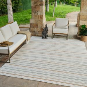 Outdoor patio with striped rug and seating area.