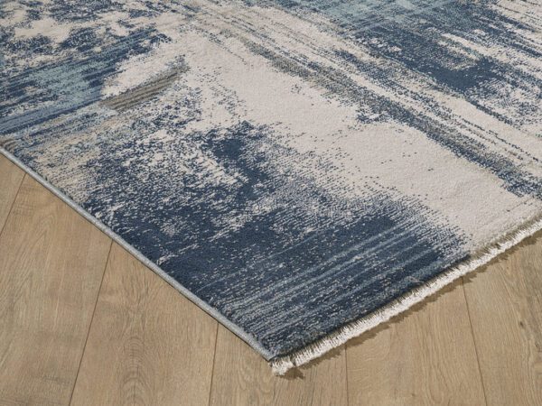 Blue and beige abstract rug on wooden floor