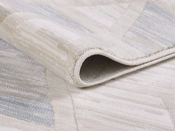 Close-up of folded beige patterned rug