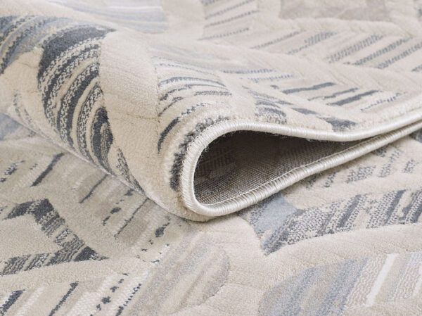 Close-up of folded patterned rug corner.