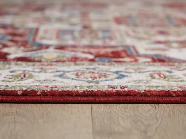 Close-up of red patterned rug on wooden floor