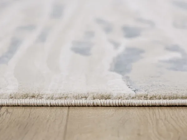 Close-up of rug on wooden floor.