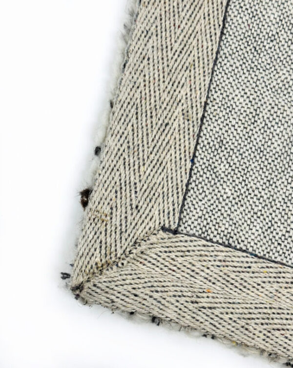 Close-up of woven textured fabric with speckled pattern.