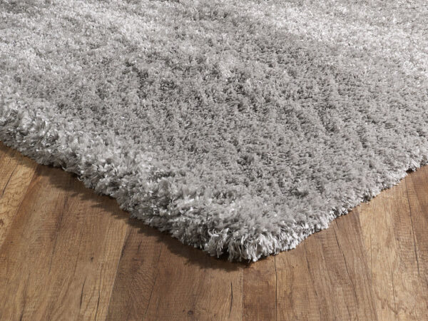 Gray shaggy rug on wooden floor