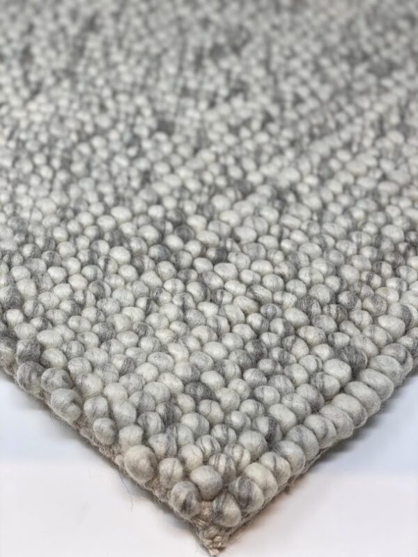 Close-up of gray textured carpet corner.