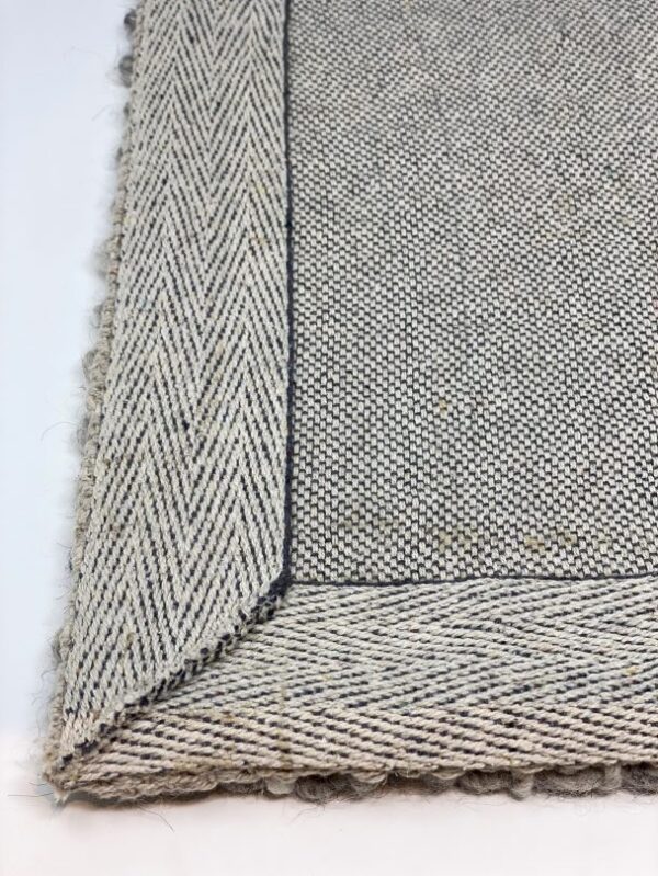 Close-up of beige woven fabric corner detail.