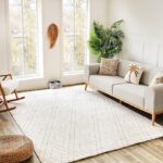 Modern living room with gray sofa and white rug.