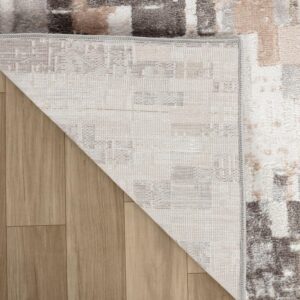 Folded corner of pattern area rug on wood floor.
