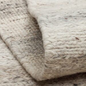 Close-up of folded cream textured wool rug