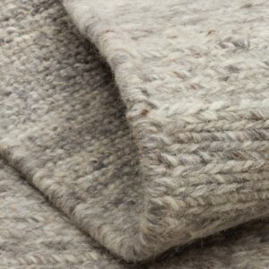 Close-up of folded gray and cream woven wool rug