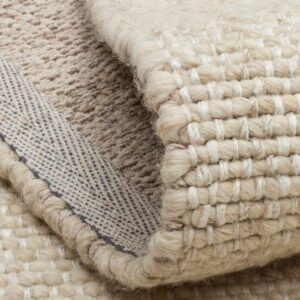 Close-up of folded cream woven rug with textured backing